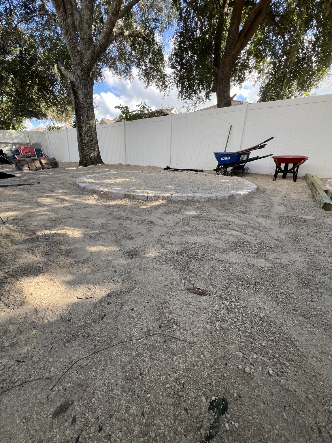 Ground being prepared inside a white fenced yard