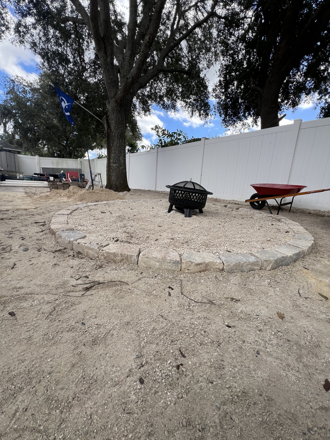 Mature backyard tree with a circular landscape border during preparation