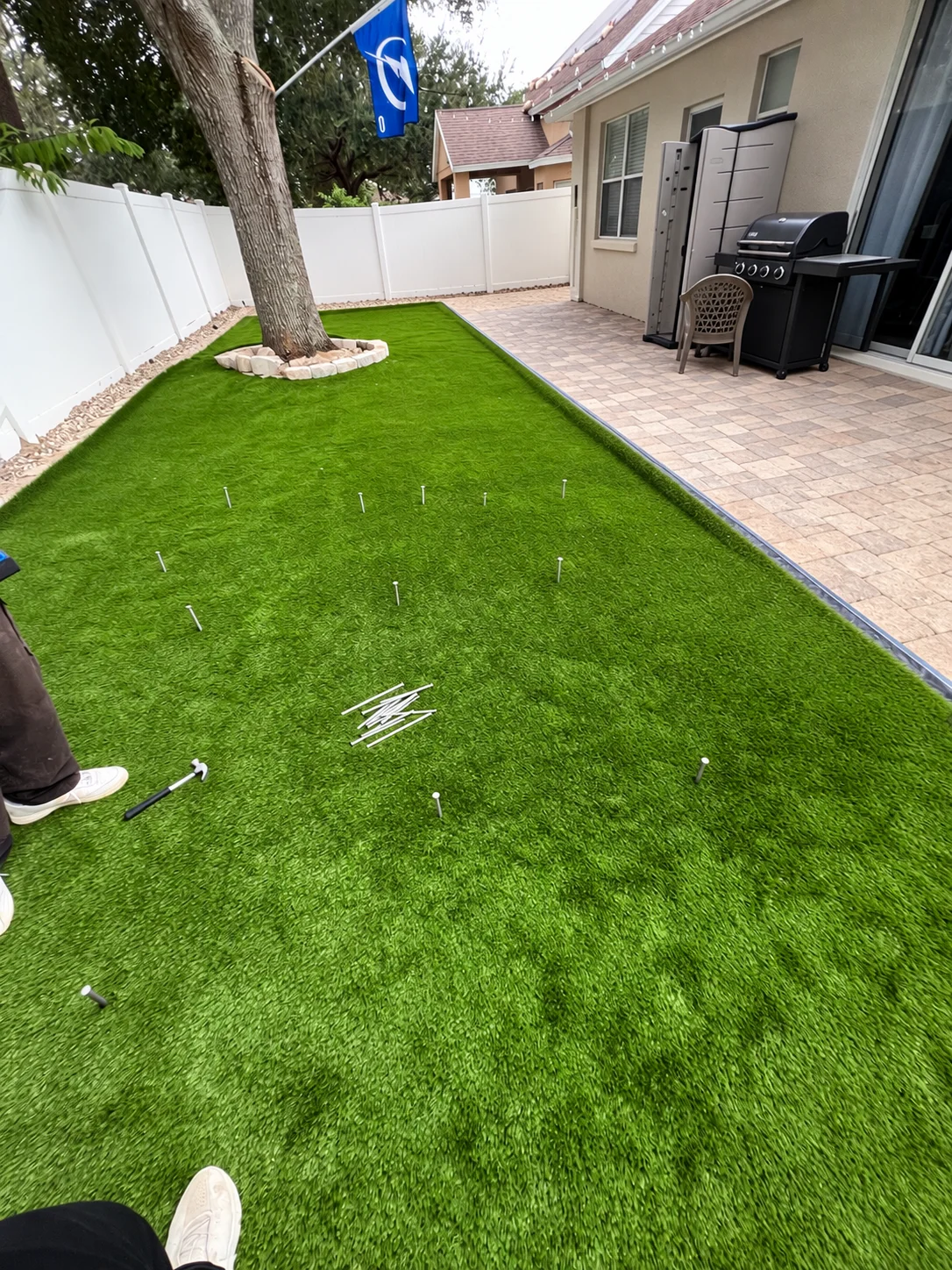 Newly installed artificial turf in a backyard beside the house