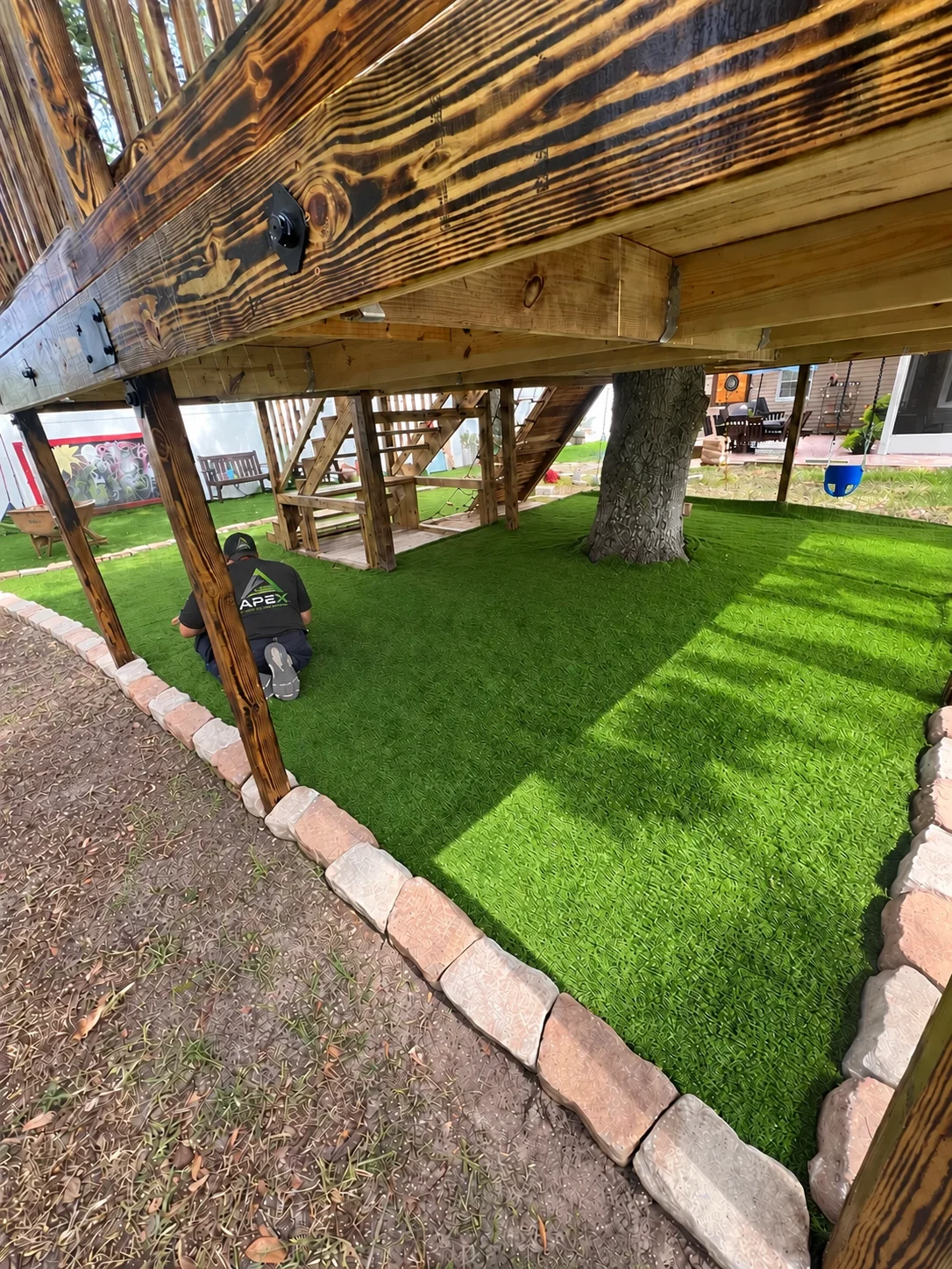 Installed artificial turf beneath an elevated play deck